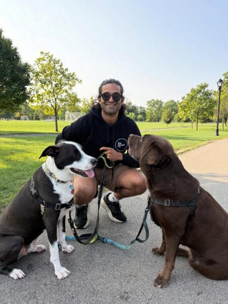 Ajay wearing sunglasses with Rayne and a chocolate lab.